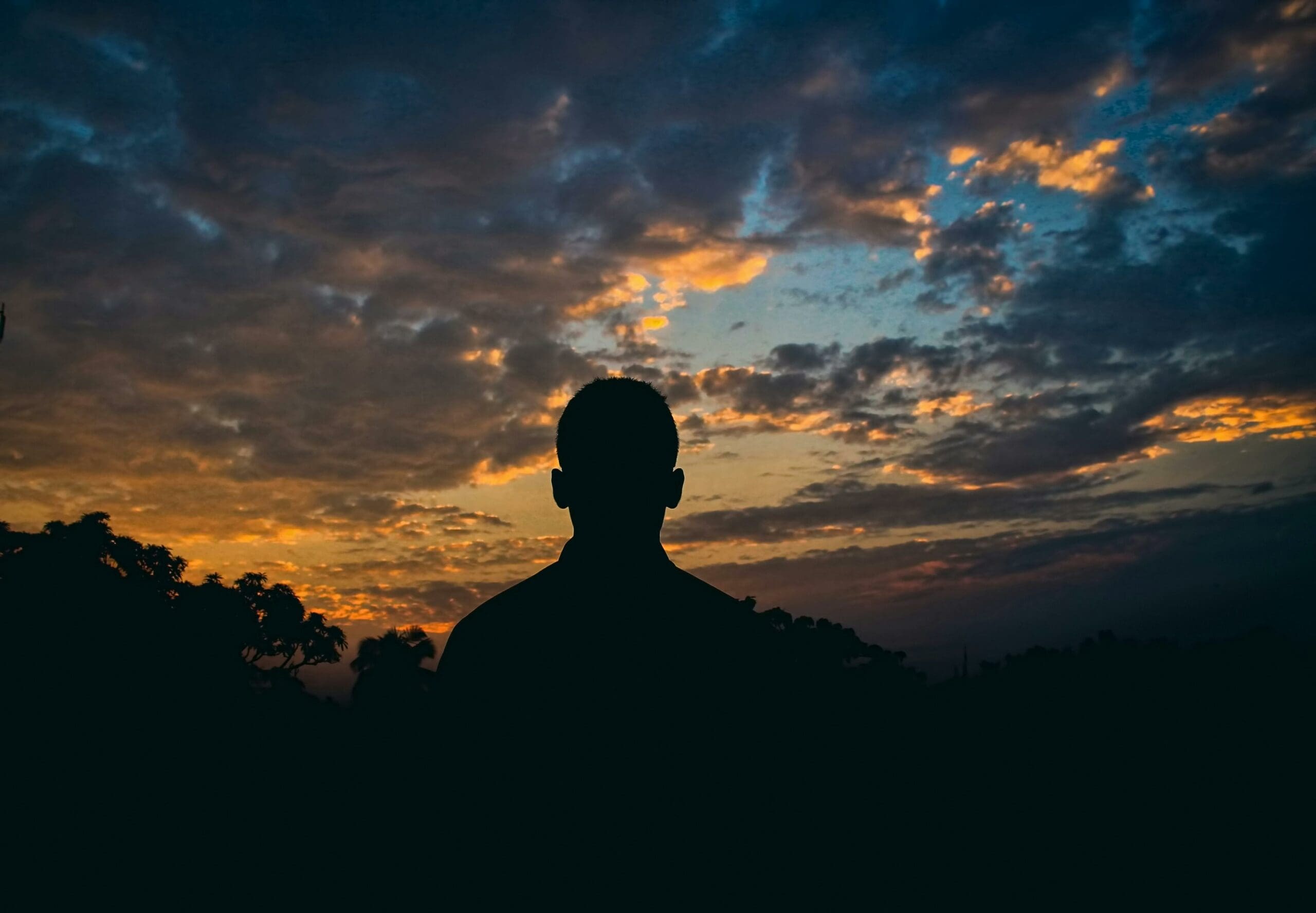 Imagen de la silueta de un hombre con el atardecer de fondo