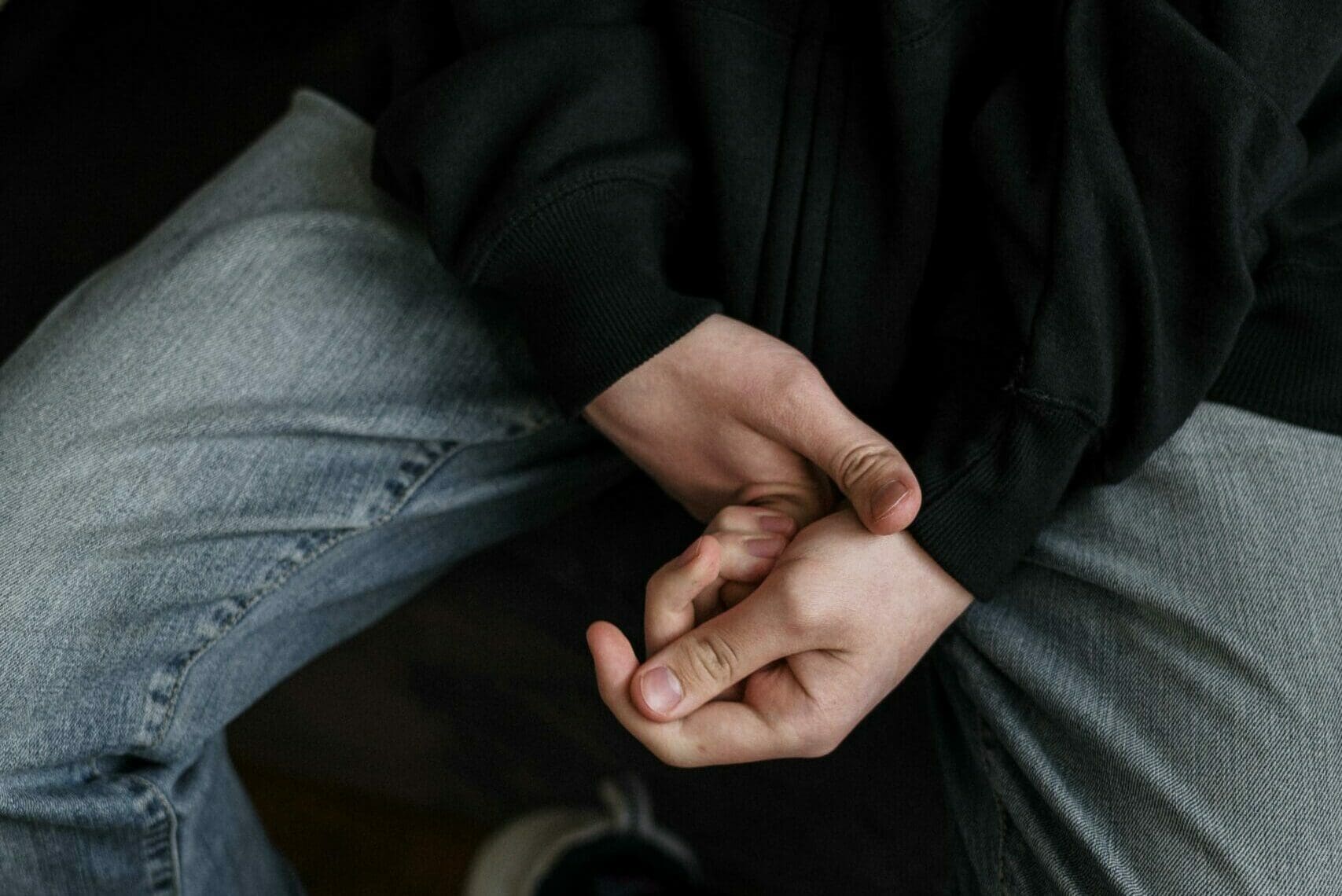 Imagen de las manos de un hombre en su regazo