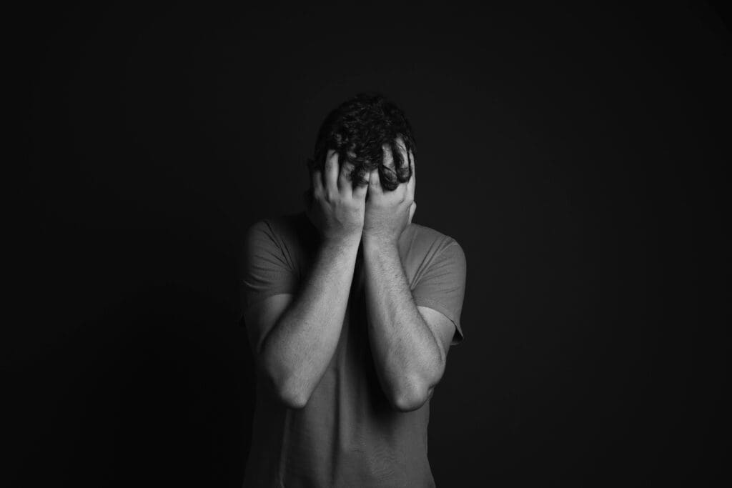 Imagen de un hombre en blanco y negro agarrándose la cabeza con las manos